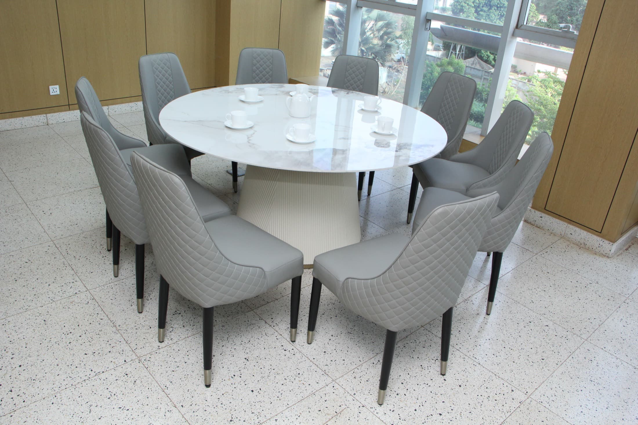 Table de salle à manger ronde en marbre et chaises en cuir matelassé gris