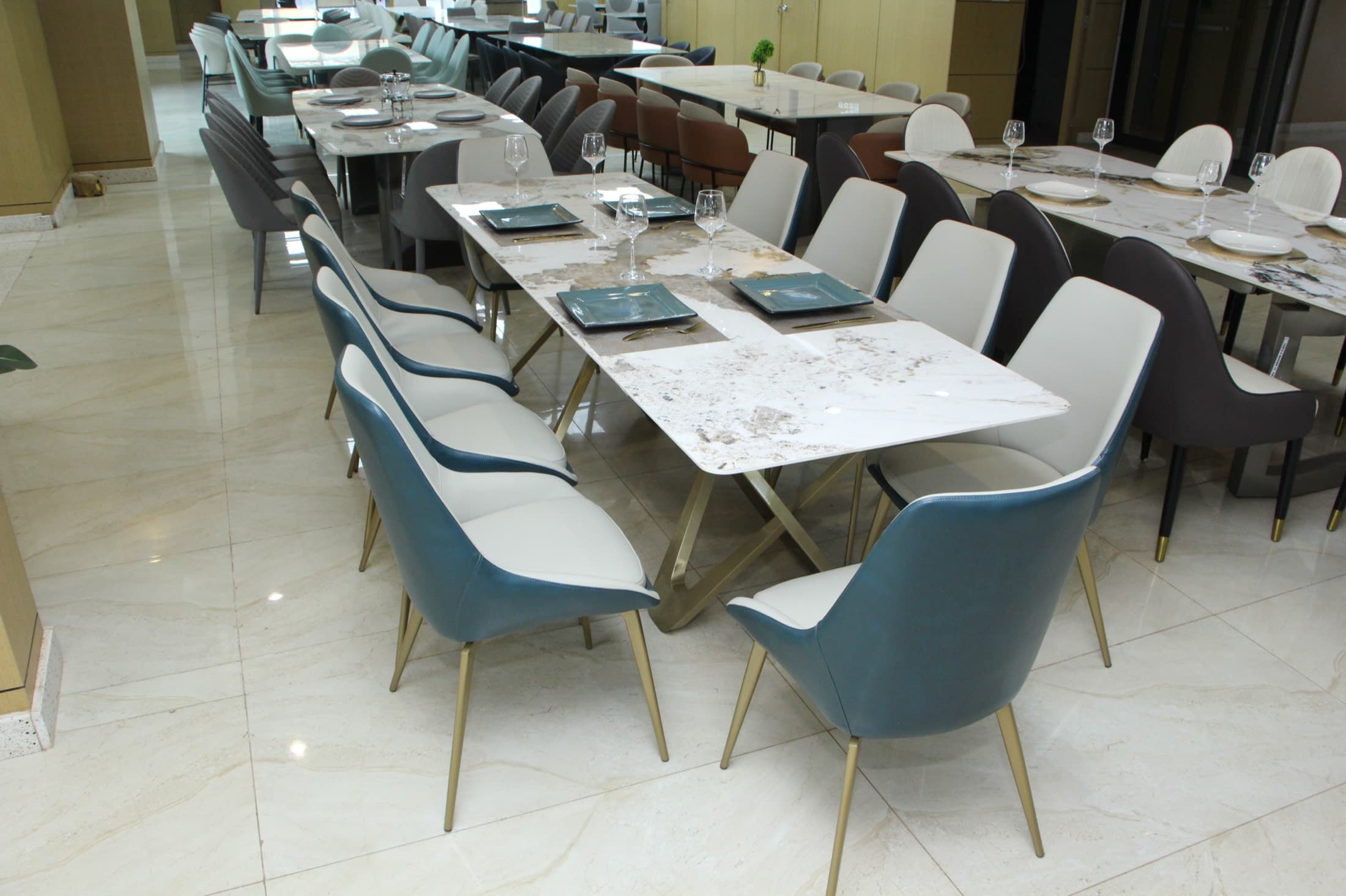 Tables de salle à manger dressées avec chaises bleu canard et crème