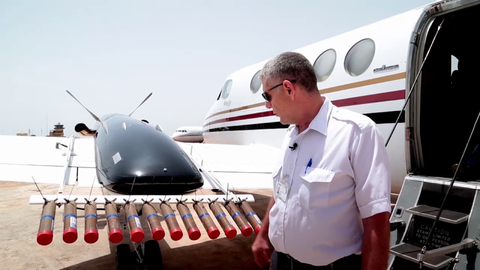 Lanceur ventral équipé de fusées d'ensemencement devant un King Air