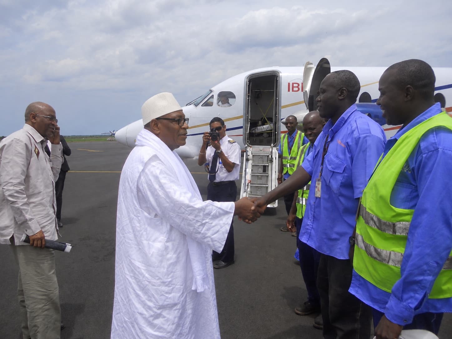 Une personnalité accueillie par l'équipe technique de Malian Aero Company au pied d'un aéronef sur le tarmac