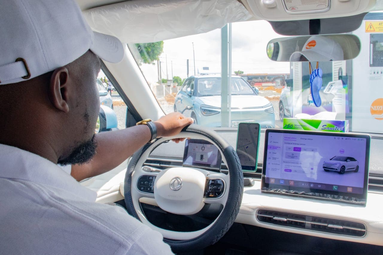 Chauffeur NDZELA au volant d'un taxi électrique équipé d'un écran de navigation et de gestion des courses